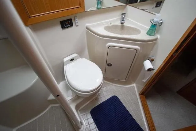 Slide: The Image of Bathroom interior of 2003 Riviera 4700 Sport Yacht with toilet, sink, and blue mat. - 45