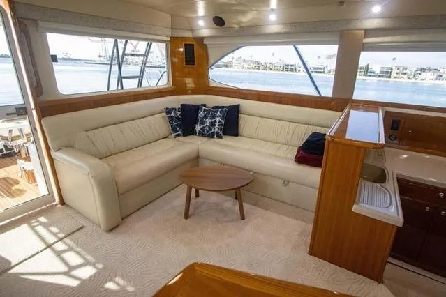 Slide: The Image of Luxurious interior of 2003 Riviera 4700 Sport Yacht with cream leather seating and wooden accents. - 5