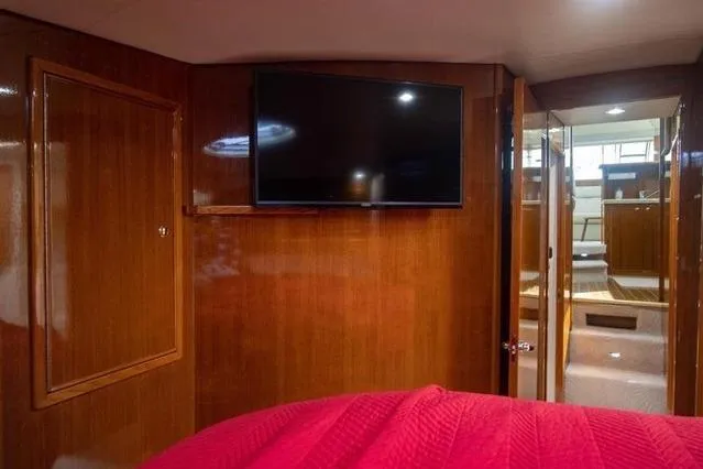 Slide: The Image of Interior of 2003 Riviera 4700 Sport Yacht with TV and wooden paneling. - 50