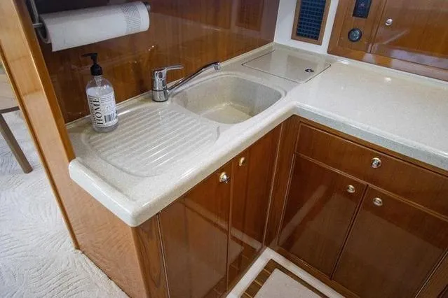 Slide: The Image of Luxurious kitchen sink area in 2003 Riviera 4700 Sport Yacht with wooden cabinetry. - 55