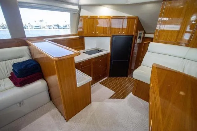 Slide: The Image of Luxurious interior of 2003 Riviera 4700 Sport Yacht with wood cabinetry and plush seating. - 59