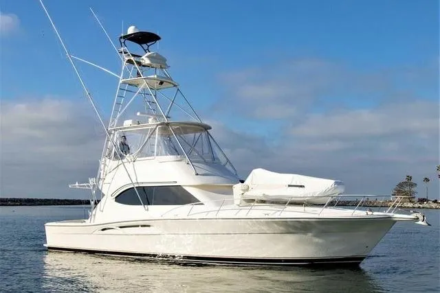 Slide: The Image of 2003 Riviera 4700 Sport Yacht on calm water under a clear blue sky. - 68