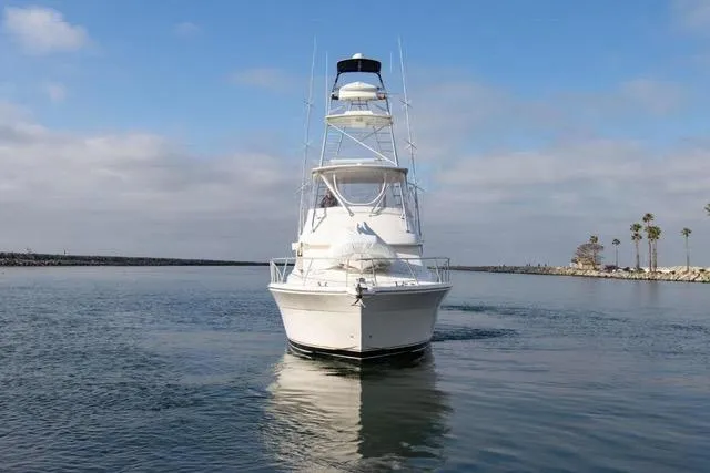 Slide: The Image of Front view of a 2003 Riviera 4700 Sport Yacht on calm water. - 7