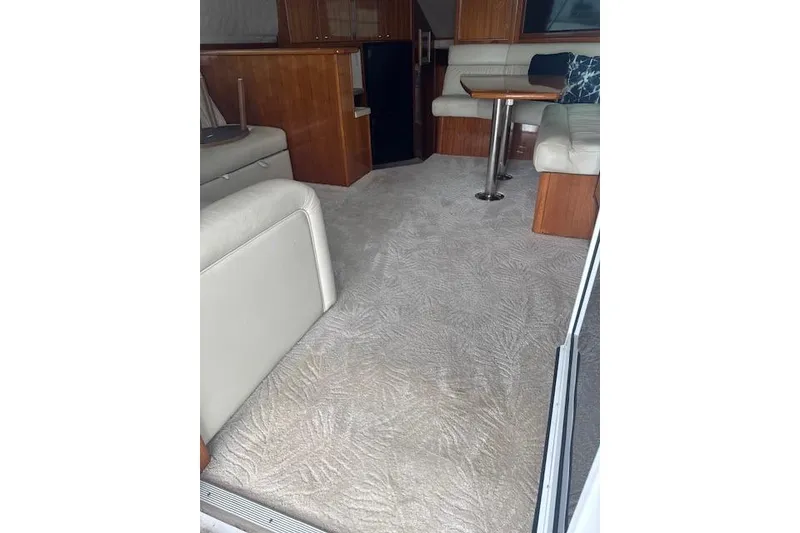 Slide: The Image of Interior of 2003 Riviera 4700 Sport Yacht with beige carpet and wooden furnishings. - 75