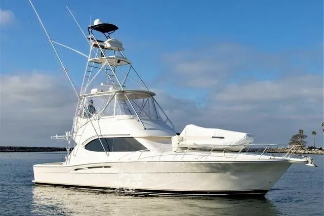 The Image of 2003 Riviera 4700 Sport Yacht on calm water under blue sky. - 1