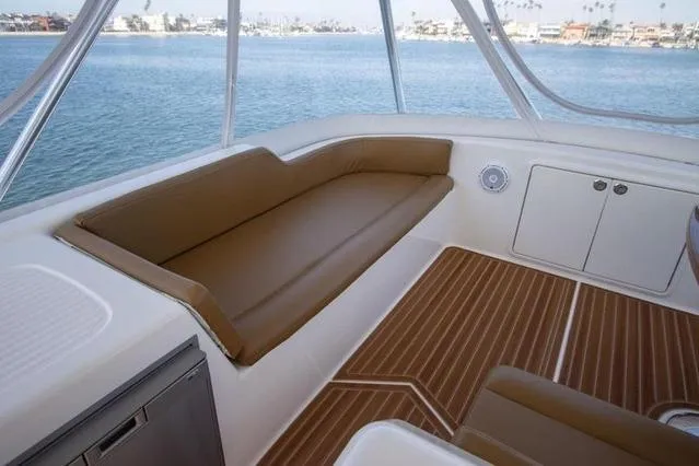 Slide: The Image of Interior of 2003 Riviera 4700 Sport Yacht with brown seating and wood flooring. - 27
