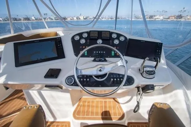 Slide: The Image of Helm of 2003 Riviera 4700 Sport Yacht with modern navigation equipment and ocean view. - 3
