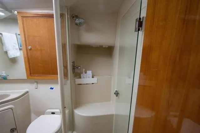 Slide: The Image of Bathroom interior of 2003 Riviera 4700 Sport Yacht with shower and wooden cabinetry. - 43
