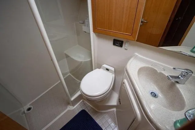 Slide: The Image of Luxurious bathroom in 2003 Riviera 4700 Sport Yacht with shower, toilet, and sink. - 46