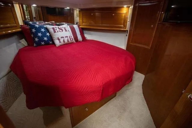 Slide: The Image of Luxurious 2003 Riviera 4700 Sport Yacht cabin with red bedding and patriotic pillows. - 47