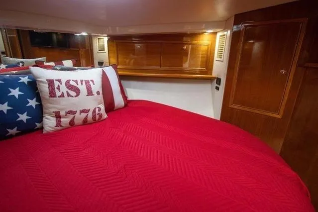Slide: The Image of Cozy bedroom in 2003 Riviera 4700 Sport Yacht with red bedding and patriotic pillows. - 48