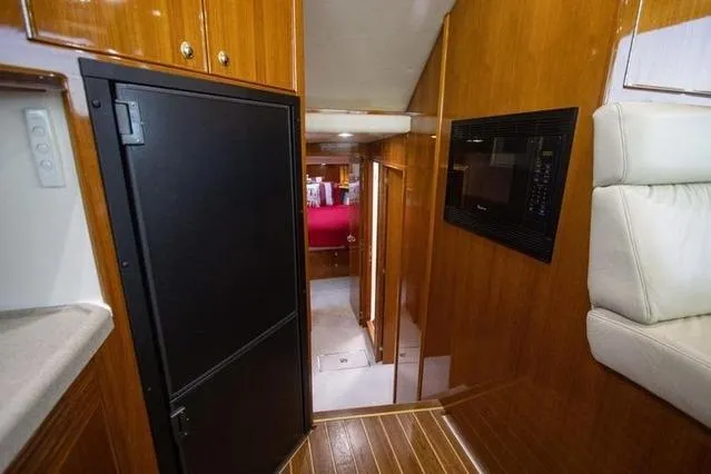 Slide: The Image of Interior of 2003 Riviera 4700 Sport Yacht with wood paneling and modern amenities. - 52