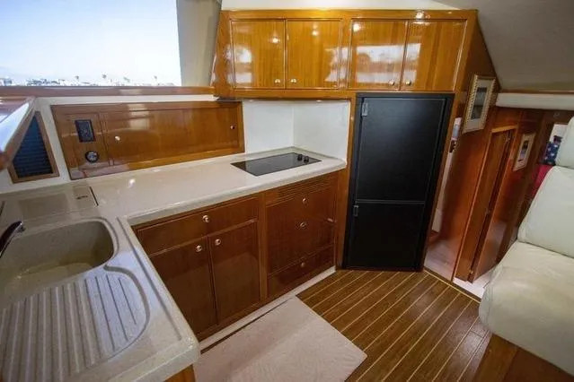 Slide: The Image of 2003 Riviera 4700 Sport Yacht kitchen with wooden cabinets and modern appliances. - 60
