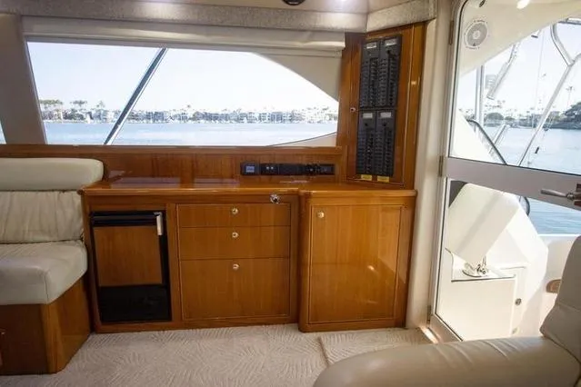 Slide: The Image of Interior of 2003 Riviera 4700 Sport Yacht with wooden cabinetry and waterfront view. - 61