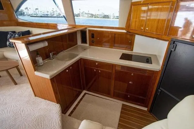 Slide: The Image of Luxurious 2003 Riviera 4700 Sport Yacht interior kitchen with wood cabinetry and modern amenities. - 65