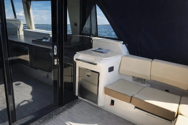 Slide: The Image of 2019 Regal 42 Grande Coupe interior with seating, kitchenette, and ocean view. - 5