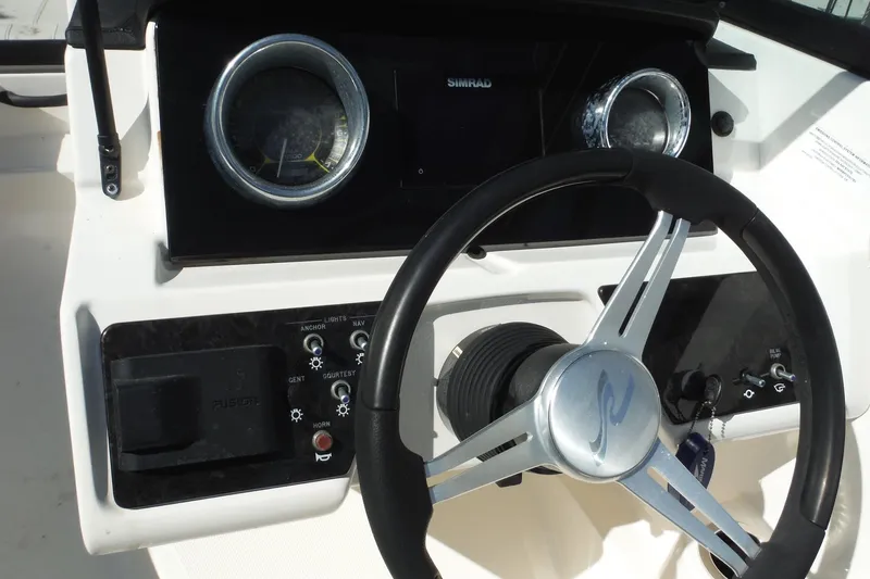 Slide: The Image of 2021 Sea Ray SPX 190 Outboard dashboard with steering wheel and control panel. - 21