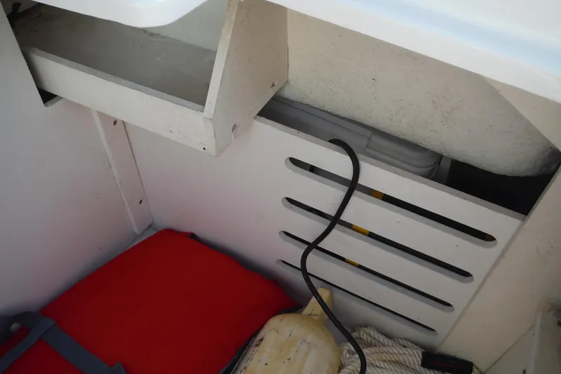 Slide: The Image of Storage compartment in a 2021 Sea Ray SPX 190 Outboard boat with equipment and cables. - 26
