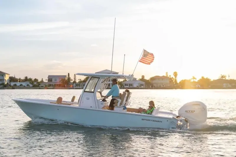 The Image of 2026 Sportsman Masters 267 Bay Boat cruising at sunset with American flag. - 1
