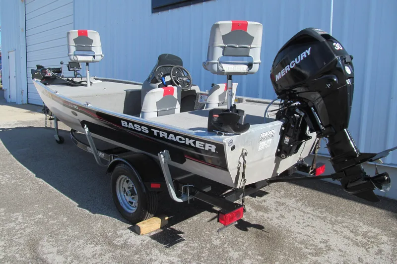 Slide: The Image of 2010 Tracker Pro 16 bass boat with Mercury engine, parked outside a building. - 2