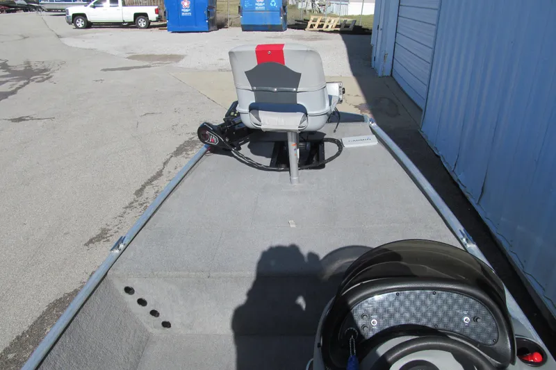 Slide: The Image of 2010 Tracker Pro 16 boat interior with seating and steering wheel, parked outdoors. - 7