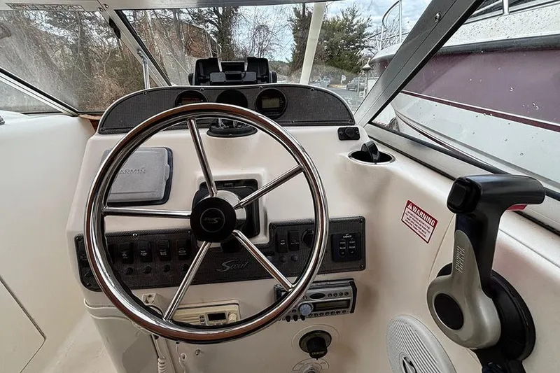 Slide: The Image of 2007 Scout 222 Dorado boat dashboard with steering wheel and control panel. - 12