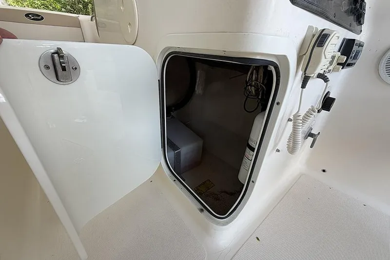 Slide: The Image of Storage compartment on a 2007 Scout 222 Dorado boat, featuring safety equipment and controls. - 21