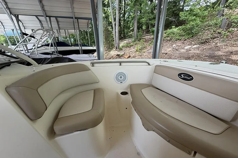 Slide: The Image of 2007 Scout 222 Dorado boat interior with beige seating under a covered dock. - 24