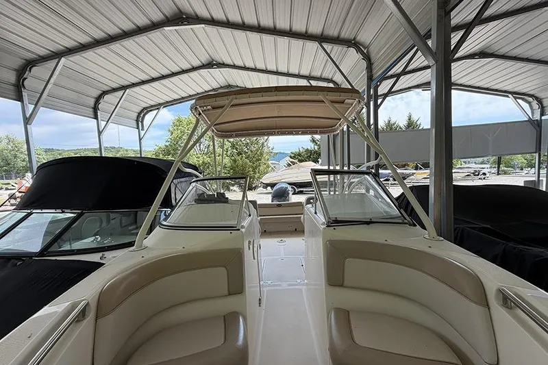 Slide: The Image of 2007 Scout 222 Dorado boat under a metal canopy, showcasing interior seating and helm. - 25