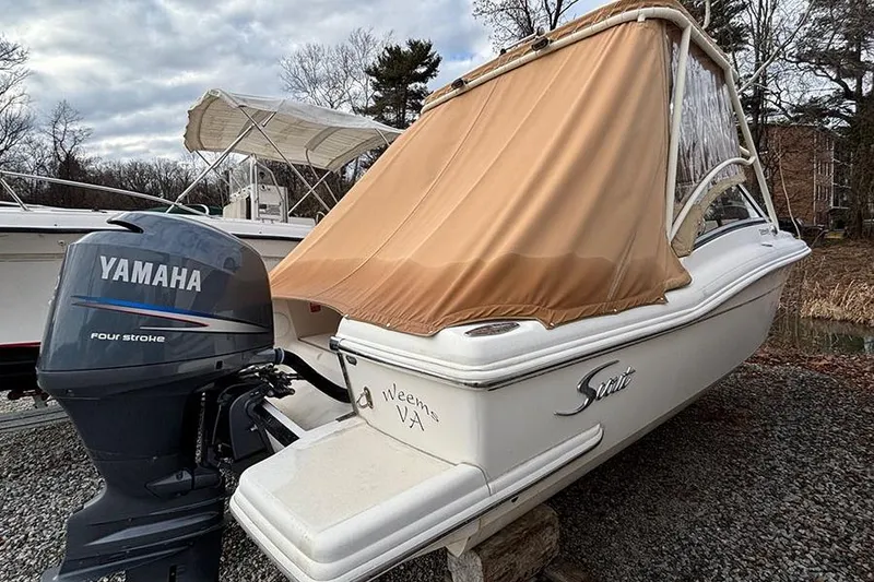 Slide: The Image of 2007 Scout 222 Dorado boat with Yamaha four-stroke engine, covered and parked outdoors. - 3