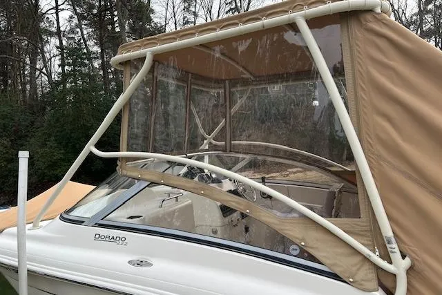 Slide: The Image of 2007 Scout 222 Dorado boat with tan canopy in wooded area. - 4