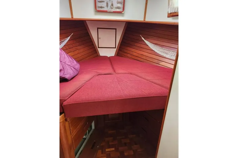 Slide: The Image of 1996 Grand Banks 36 Sedan interior with red cushioned bed and wooden paneling. - 10