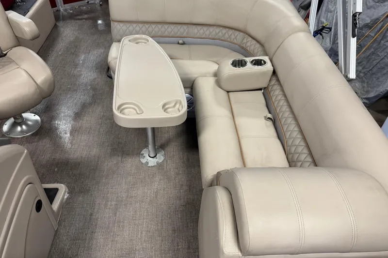 Slide: The Image of 2020 Ranger Reata 220F boat interior with beige seating and table. - 12