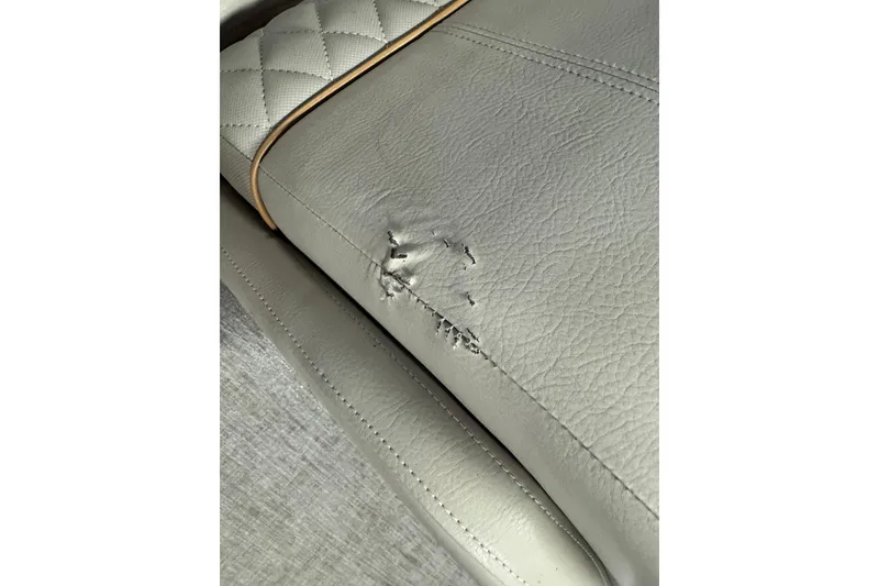 Slide: The Image of Damaged leather seat on 2020 Ranger Reata 220F boat, showing tear and stitching detail. - 21