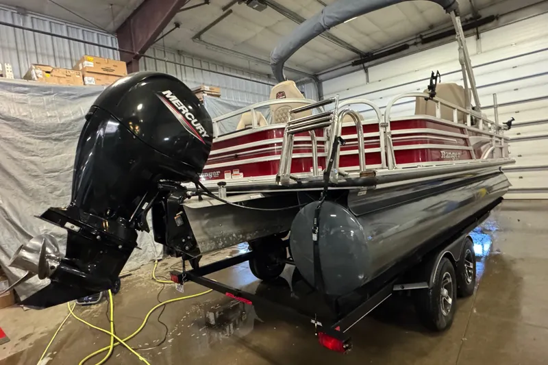 Slide: The Image of 2020 Ranger Reata 220F pontoon boat with Mercury outboard motor in a garage. - 4