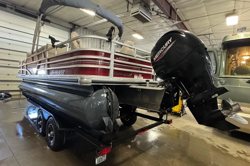 Slide: The Image of 2020 Ranger Reata 220F pontoon boat with Mercury outboard motor in a garage. - 5