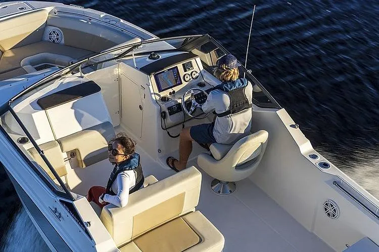 Slide: The Image of 2024 Boston Whaler 210 Vantage boat interior with two people navigating on water. - 17