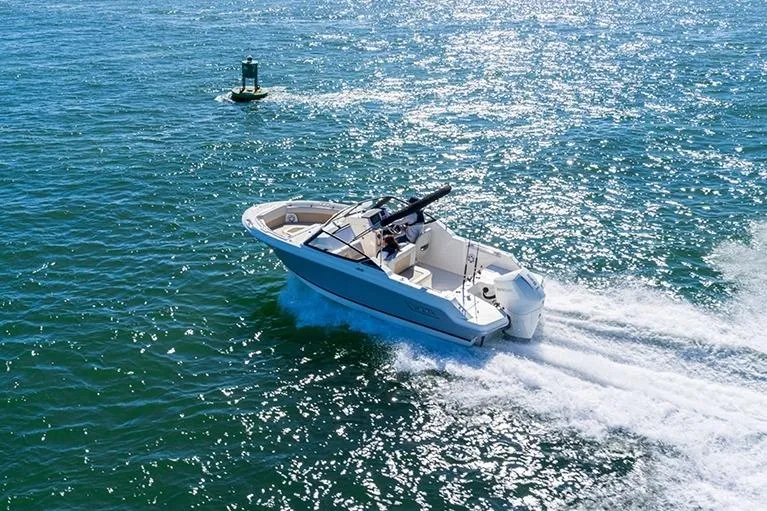 Slide: The Image of 2024 Boston Whaler 210 Vantage cruising on sparkling blue water. - 20