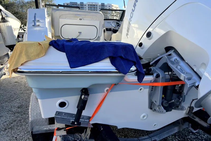Slide: The Image of 2024 Boston Whaler 210 Vantage boat with Mercury engine, docked and covered with towels. - 27