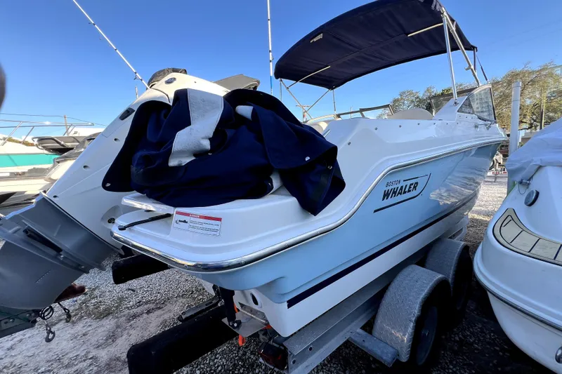 Slide: The Image of 2024 Boston Whaler 210 Vantage boat on trailer, covered with a blue tarp. - 39