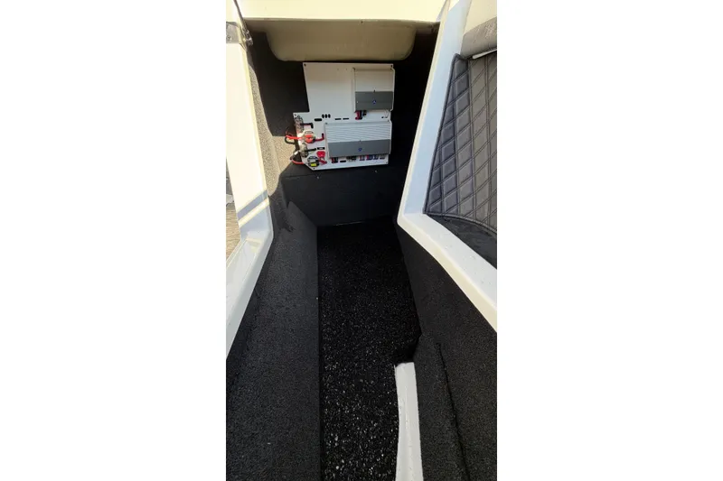Slide: The Image of 2024 Boston Whaler 210 Vantage interior storage compartment with electrical components. - 6