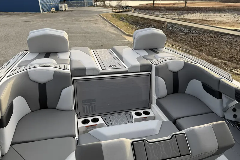 Slide: The Image of 2023 MasterCraft XT24 boat interior with gray seating and cup holders. - 13