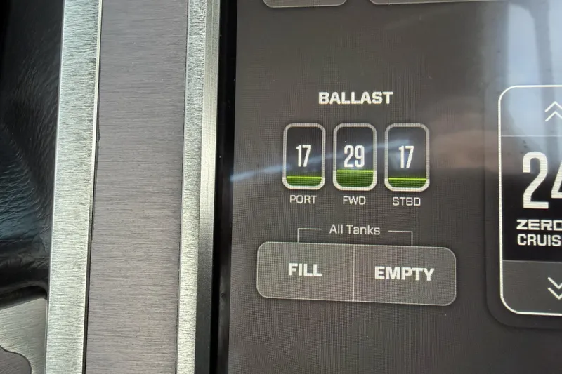 Slide: The Image of 2023 MasterCraft XT24 ballast control panel displaying tank levels and fill options. - 21