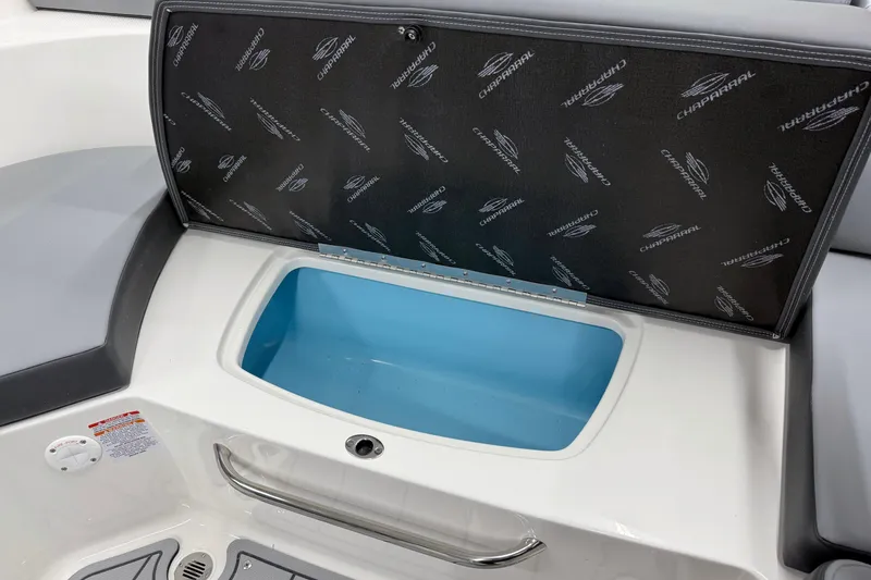 Slide: The Image of 2026 Chaparral 23 SSi boat storage compartment with open lid, featuring branded interior. - 22