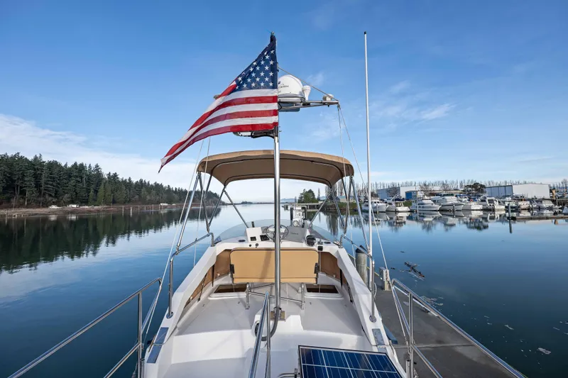 Slide: The Image of 2014 Ranger Tug R-31 CB boat with American flag on calm water, marina background. - 17