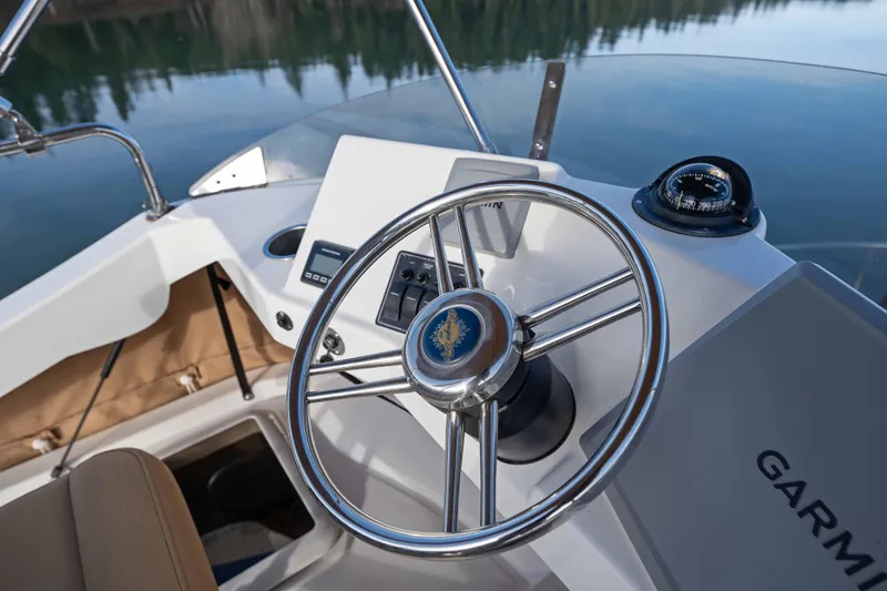 Slide: The Image of Steering wheel and controls of 2014 Ranger Tug R-31 CB boat on calm water. - 18