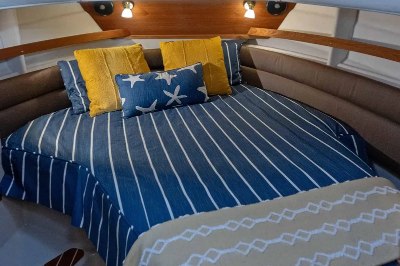 Slide: The Image of Cozy cabin interior of 2014 Ranger Tug R-31 CB with striped bedding and decorative pillows. - 26