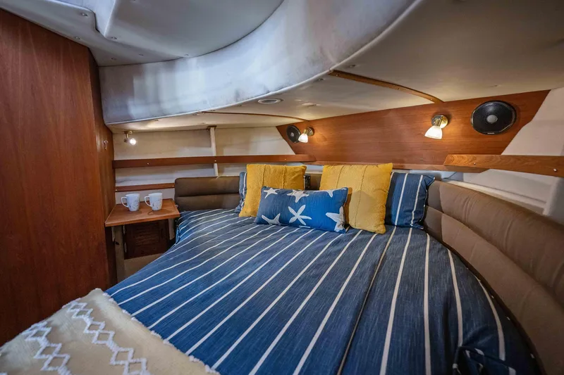 Slide: The Image of Cozy cabin interior of 2014 Ranger Tug R-31 CB with striped bedding and decorative pillows. - 28