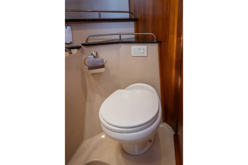 Slide: The Image of 2014 Ranger Tug R-31 CB bathroom with modern toilet and wooden accents. - 29