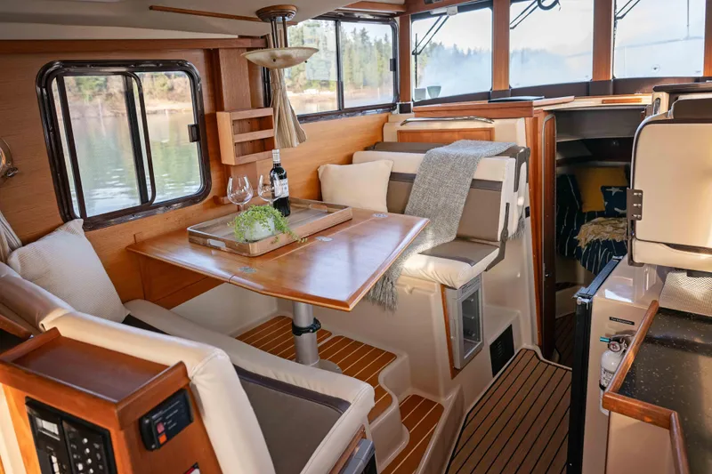 Slide: The Image of Cozy interior of 2014 Ranger Tug R-31 CB with dining area and scenic window views. - 3